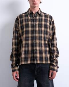 Model wearing Relaxed fit crop flannel shirt in brown check