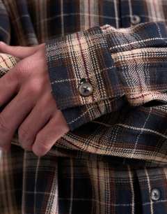 Model wearing Relaxed fit crop flannel shirt in brown check