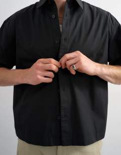 Model wearing Relaxed fit crop poplin short sleeve shirt in black