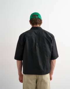 Model wearing Relaxed fit crop poplin short sleeve shirt in black