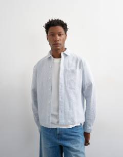 Model wearing Relaxed fit crop seersucker shirt in light blue