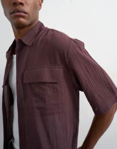 Model wearing Relaxed fit crop sheer ripstop short sleeve shirt in brown