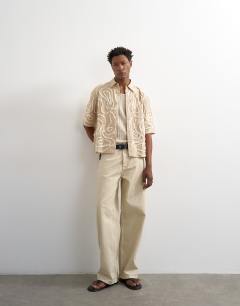 Model wearing Relaxed fit crop shirt with all over floral rope applique in stone
