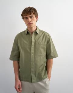 Model wearing Relaxed fit crop short sleeve herringbone overshirt in olive green