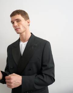 Model wearing Relaxed fit double breasted tuxedo blazer in black