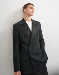 Model wearing Relaxed fit double breasted tuxedo blazer in black