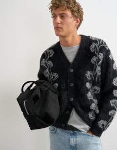 Model wearing Relaxed fit fluffy knit cardigan with floral design in black