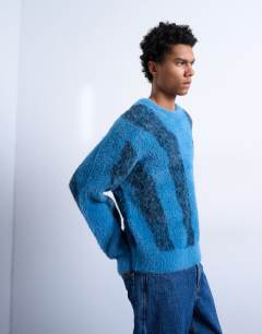 Model wearing Relaxed fit fluffy knitted jumper with stripe design in blue