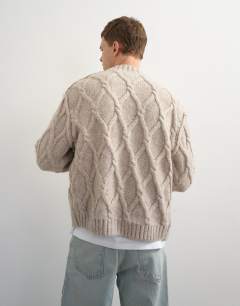 Model wearing Relaxed fit knitted cable cardigan in oatmeal