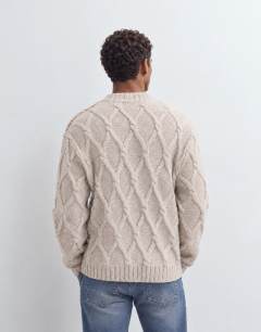 Model wearing Relaxed fit knitted cable cardigan in oatmeal