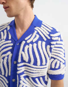 Model wearing Relaxed fit knitted shirt with all over boucle floral applique in blue