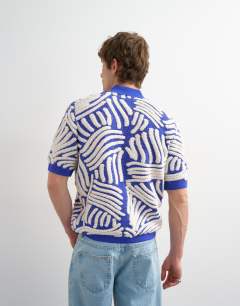 Model wearing Relaxed fit knitted shirt with all over boucle floral applique in blue