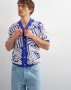 Model wearing Relaxed fit knitted shirt with all over boucle floral applique in blue