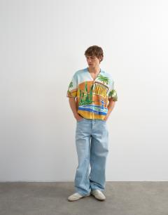Model wearing Relaxed fit knitted shirt with printed garden scene in multi