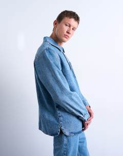 Model wearing Relaxed fit overhead denim shirt in mid wash