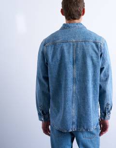 Model wearing Relaxed fit overhead denim shirt in mid wash