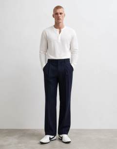 Model wearing Relaxed fit pinstripe trousers in navy