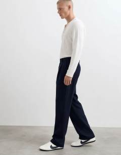 Model wearing Relaxed fit pinstripe trousers in navy