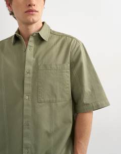 Model wearing Relaxed fit short sleeve herringbone crop overshirt in contrast olive
