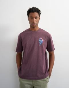 Model wearing Relaxed fit t-shirt with front and black floral embroidery in purple