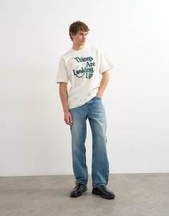 Model wearing Relaxed fit t-shirt with things are looking up embroidery in ecru