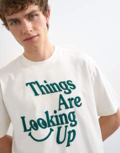 Model wearing Relaxed fit t-shirt with things are looking up embroidery in ecru