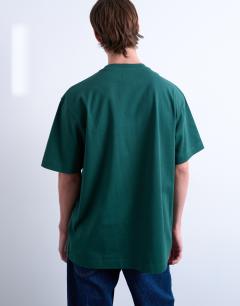 Model wearing Relaxed NYC apple print t-shirt in dark green 