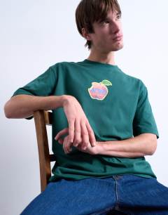 Model wearing Relaxed NYC apple print t-shirt in dark green 