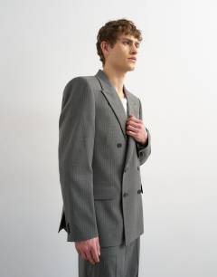Model wearing Relaxed pinstripe double breasted suit jacket in charcoal
