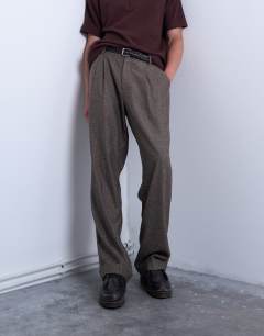 Model wearing Relaxed tapered pleated herringbone trouser in brown