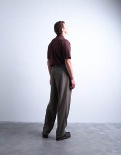 Model wearing Relaxed tapered pleated herringbone trouser in brown