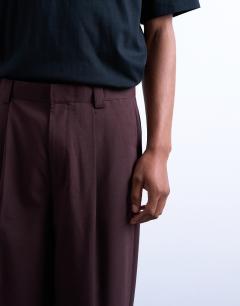 Model wearing Relaxed tapered trousers in burgundy