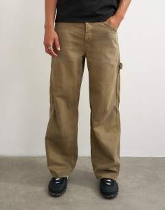 Model wearing Rigid baggy fit carpenter jean in tan