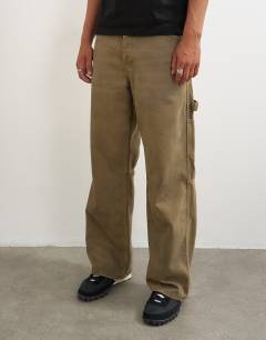 Model wearing Rigid baggy fit carpenter jean in tan