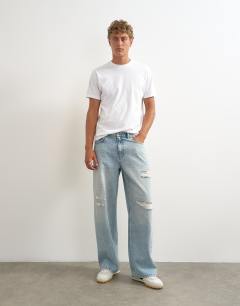 Model wearing Rigid baggy fit distressed jean in light wash