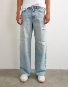 Model wearing Rigid baggy fit distressed jean in light wash