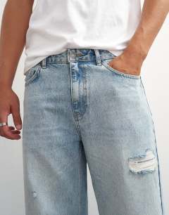 Model wearing Rigid baggy fit distressed jean in light wash