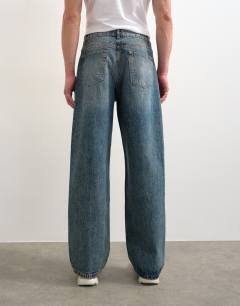 Model wearing Rigid baggy jean in mid wash tint