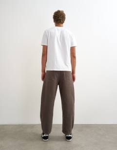 Model wearing Rigid barrel fit jean in clean brown