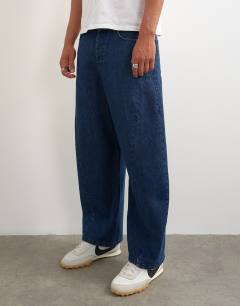 Model wearing Rigid barrel fit jean in dark wash