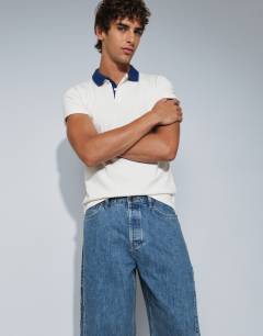 Model wearing Rigid barrel fit jean in mid wash