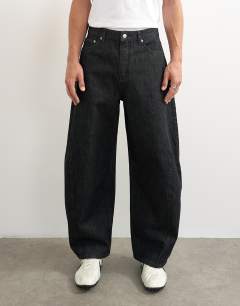 Model wearing Rigid barrel fit jean in raw black
