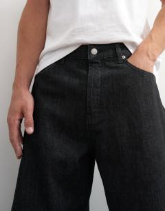 Model wearing Rigid barrel fit jean in raw black