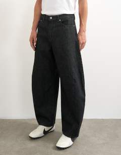Model wearing Rigid barrel fit jean in raw black