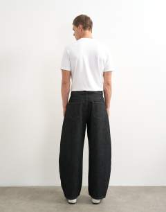 Model wearing Rigid barrel fit jean in raw black