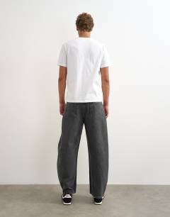 Model wearing Rigid barrel fit jean in washed black