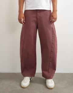 Model wearing Rigid barrel fit jean in washed burgundy