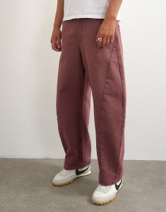 Model wearing Rigid barrel fit jean in washed burgundy
