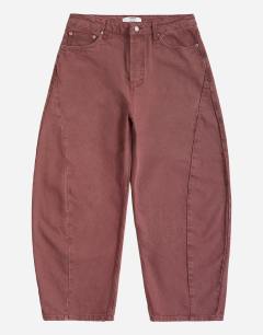 Model wearing Rigid barrel fit jean in washed burgundy