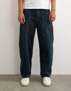 Model wearing Rigid barrel fit panelled jean in clean dark wash